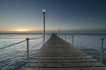 Obraz premium Sunrise over the sea and a light wooden pier.