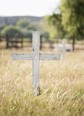 Old Wooden Cross in a Historic Cemetery with Beautiful Grassy & Tree Filled Backgrounds in a Peaceful Setting