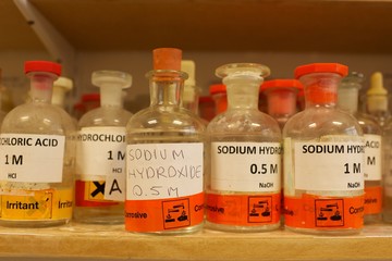 Various bottles of chemicals including Sodium hydroxide in a school chemistry lab