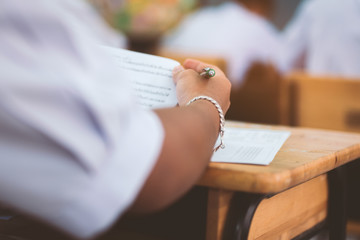 Obraz premium School students taking exam writing answer in classroom with stress