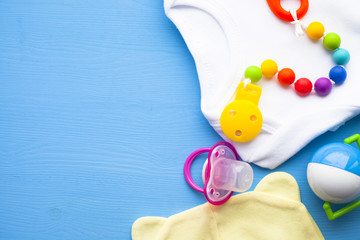 Baby yellow booties. Children's shoes and toys on blue background. Newborn.