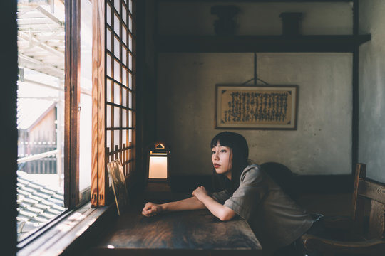 Portrait of woman looking over window