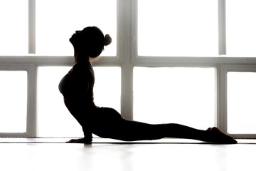 Young sporty yogi woman practicing yoga, doing upward facing dog exercise, Urdhva mukha shvanasana...