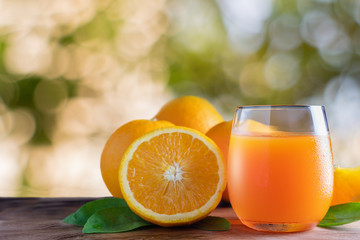 Glass of orange juice with fresh fruits on wooden floor