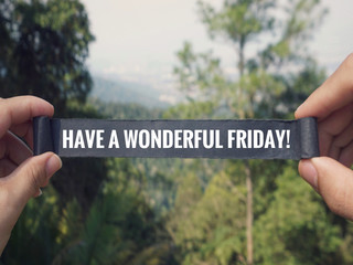 Motivational and inspirational greeting - ‘Have a wonderful Friday’ written on a black paper. Vintage styled background.