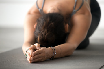 Young attractive woman practicing yoga, doing meditation exercise, relaxation pose, working out,...
