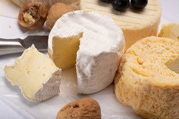 French AOC soft cow cheeses, crumbly Langres with washed rind structure, sharp Pie Angloys, camembert with strong taste and brie served as dessert after dinner