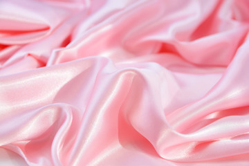 The texture of the satin fabric of pink color for the background  