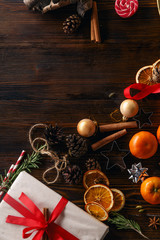 Christmas atmoshpere flatlay. Overhead view. Gingerbread cookies, tangerines and new year decorations on wooden background