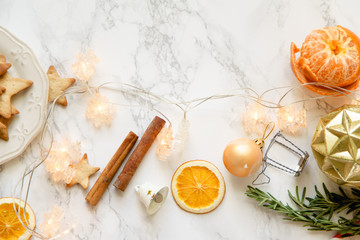 Christmas atmoshpere flatlay. Overhead view. Gingerbread cookies, tangerines and new year decorations on marble background