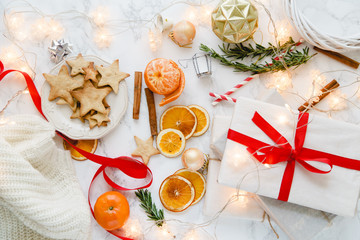 Christmas atmoshpere flatlay. Overhead view. Gingerbread cookies, tangerines and new year decorations on marble background
