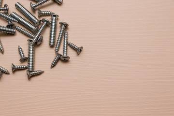 Self-tapping screw on a wooden background. 