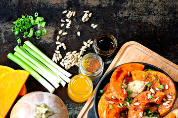 Pumpkin pieces baked in a small frying pan with greens and seeds. Baked pumpkin. Vegan lunch with spicy baked pumpkin. Useful autumn snack. Halloween lunch.