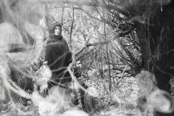 Woman in a witch suit in a dense forest