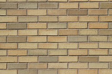 Vintage yellow brick wall background in varying shades yellow, beige, pink and tan