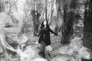 Woman in a witch suit in a dense forest