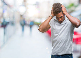 Fototapeta premium Afro american man over isolated background suffering from headache desperate and stressed because pain and migraine. Hands on head.