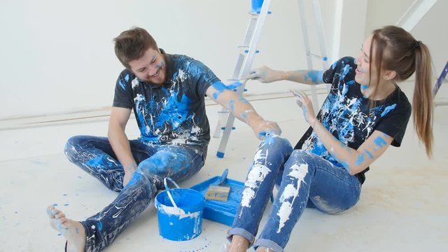 Young happy couple having fun while renovation and painting their flat