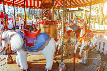 Children outdoor colourful vintage Merry-Go-Round flying horse carousel in amusement holliday park...