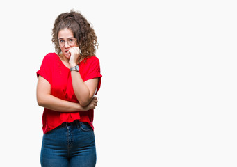 Beautiful brunette curly hair young girl wearing glasses over isolated background looking stressed and nervous with hands on mouth biting nails. Anxiety problem.