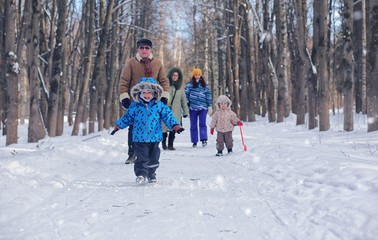 Fototapeta na wymiar Kid playing in a winter park and have fun with family