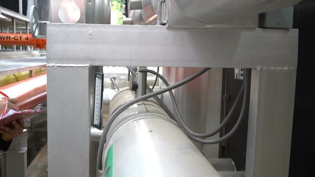 Asian Maintenance engineer at the waste water management system of a huge factory,maintenance checking technical data of heating system equipment,Thailand people	