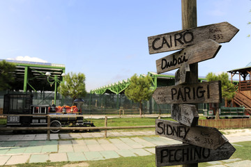 Street signs in the natural park indicating directions to different places of the world. A...
