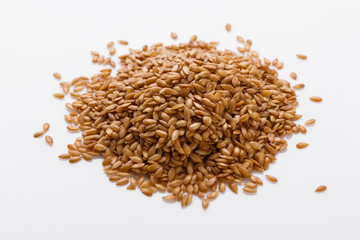 Seeds of golden flax on a white background