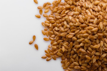 Seeds of golden flax on a white background
