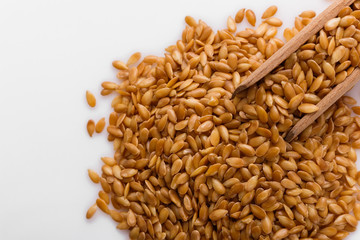 Seeds of golden flax on a white background