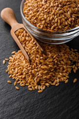 seeds of golden flax on a dark stone background