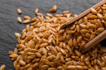 seeds of golden flax on a dark stone background