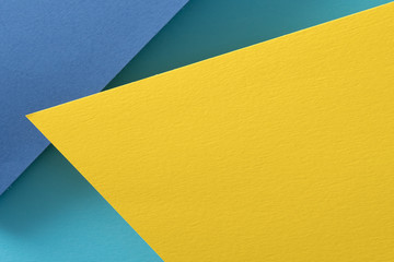 layered construction paper background. yellow and blue color abstract design with copyspace.