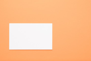 blank white paper on orange background. copy space for message or text. communication and advertisement concept.