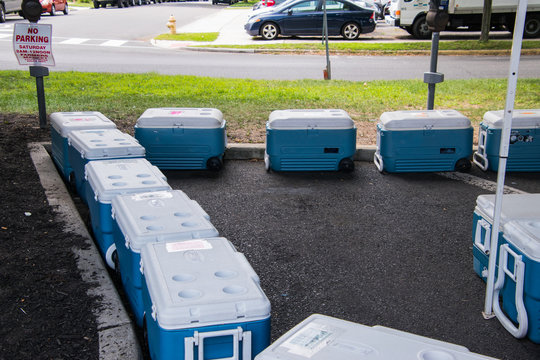 Blue Coolers With White Tops Lined Lined Up.