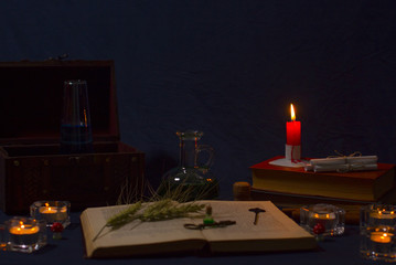 Magic potion, ancient books and candles on dark background. Fairy magic and Halloween.