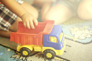 Fototapeta premium Little Asian child playing with lots of colorful plastic blocks indoor. Kid boy wearing colorful shirt and having fun with building and creating.