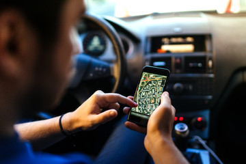 Driver using gps navigation system, online maps and smartphone for guidance