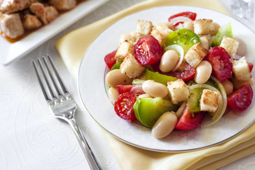 Salad with tomatoes, boiled white kidney beans and croutons from white bread