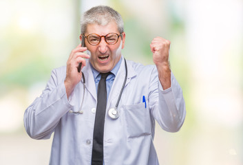 Handsome senior doctor man talking on smarpthone over isolated background annoyed and frustrated shouting with anger, crazy and yelling with raised hand, anger concept