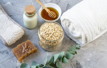 Obraz na płótnie Canvas Natural Ingredients Homemade Body Oatmeal Sea Salt Scrub with Olive Oil Honey Milk White Towel Beauty Concept Skincare Organic Aroma Spa Therapy