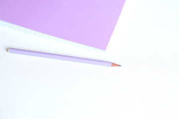 Pink notebook and pencil on white background. Selective focus