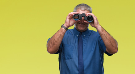 Handsome senior man looking through binoculars over isolated background with a happy face standing and smiling with a confident smile showing teeth