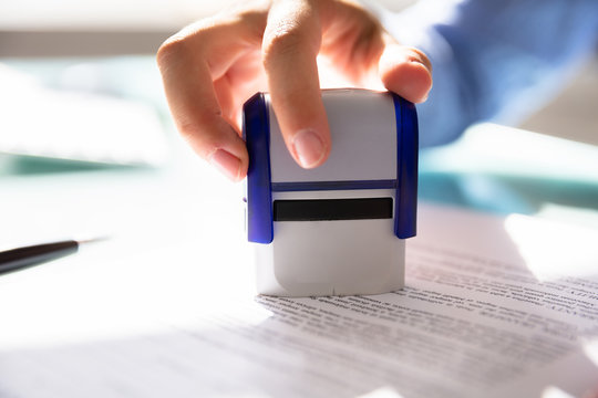 Businesswoman Stamping On Approved Contract Form
