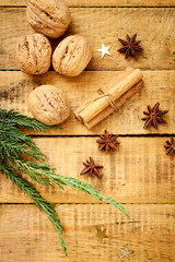 beautiful Christmas Eve background on an old wooden table with decorations vanilla sticks and nuts
