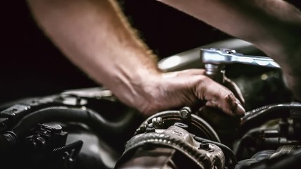 Auto mechanic working on car engine in mechanics garage. Repair service. authentic close-up shot - Powered by Adobe