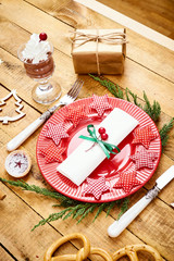 beautiful Christmas Eve background on an old wooden table with a red plate with a knife and fork