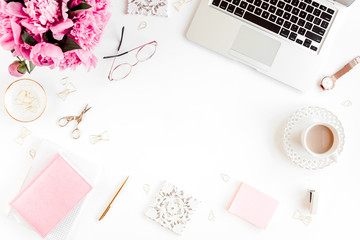 Flat lay women's office desk. Female workspace with laptop, pink peonies bouquet, accessories on...