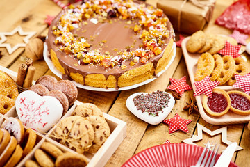 old wooden table with delicious Christmas cake decorations and different cookies