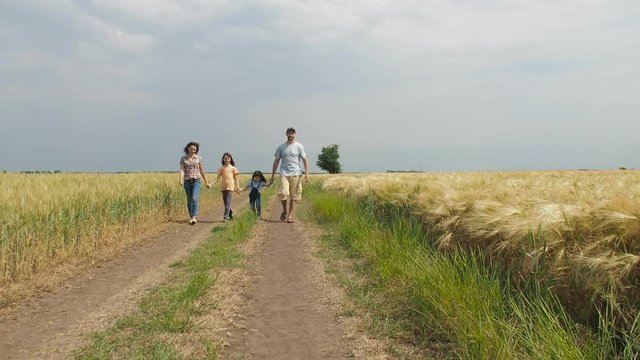 Happy family in nature. Parents with children walk in a wheat field. Farmers with children in the field.